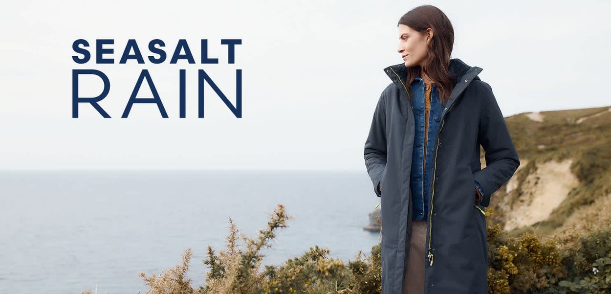 Waterdichte marineblauwe regenjas met een capuchon, rits aan de voorkant en een bicolor ontwerp. Kenmerkt zich door gedetailleerde stiksels en gele ritsaccenten.