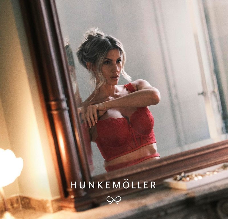 Roter Spitzen-BH mit floralem Muster und transparenten Einsätzen, mit dekorativem Detail vorne in der Mitte und passendem Band. Spiegelreflexion inklusive.