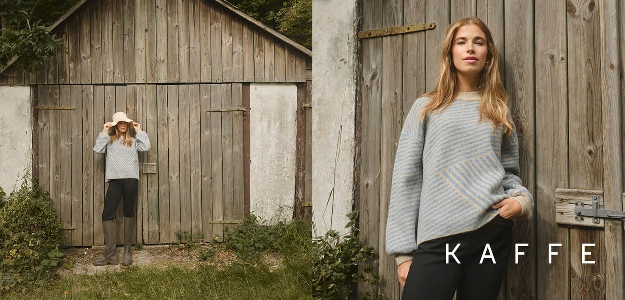 Grå- og blåstribet sweater med et geometrisk mønster, parret med sorte bukser og brune vandtætte støvler, mod en træbaggrund.