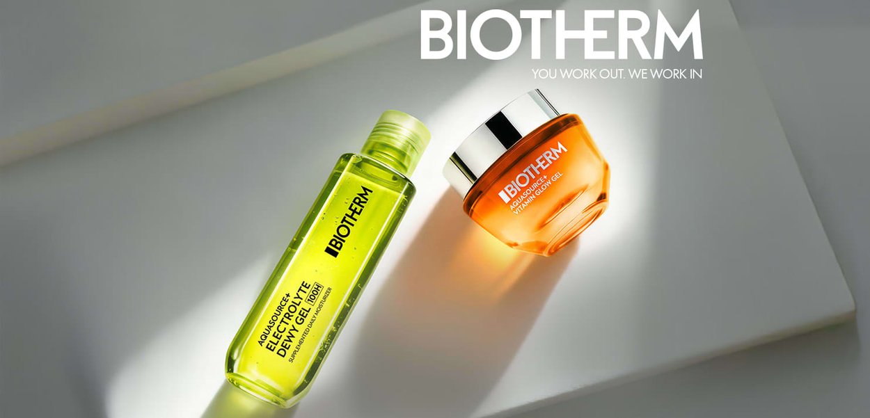 Biotherm Aquasource Electrolyte Defense Gel in gelber Flasche und Aquasource Vitamin C Glow Gel im orangenen Tiegel auf weißer Oberfläche mit Markenlogo darüber.