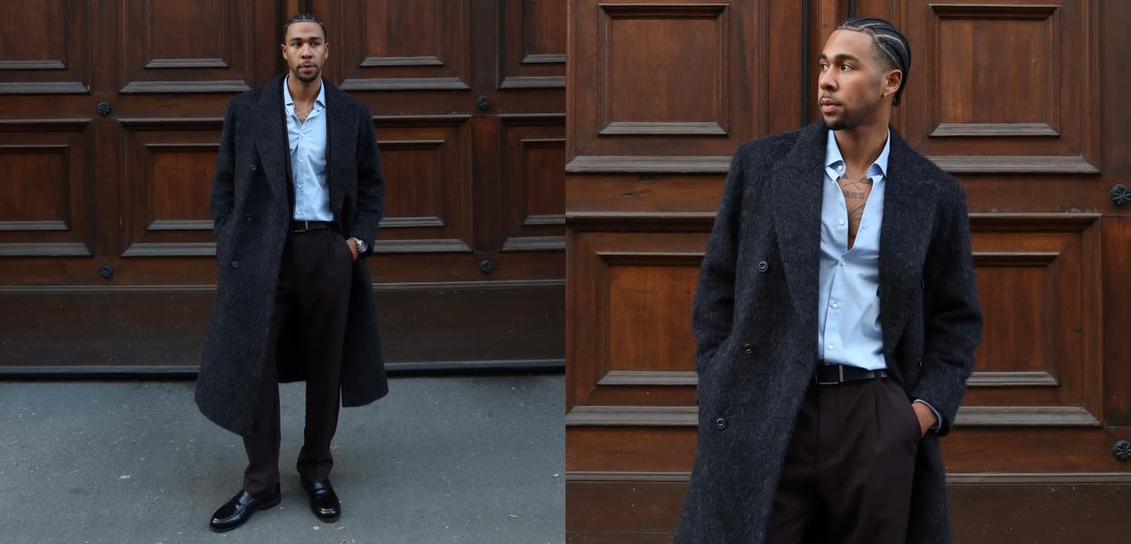 Długi ciemnoszary płaszcz wykonany z teksturowanej tkaniny, noszony na jasnoniebieskiej koszuli i ciemnych spodniach, uzupełniony błyszczącymi czarnymi butami.