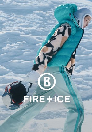 Turquoise gewatteerd vest over een zwart- en bruingevlekt fleece, gecombineerd met licht turquoise broek. Handschoenen en een helm maken de winteroutfit compleet.