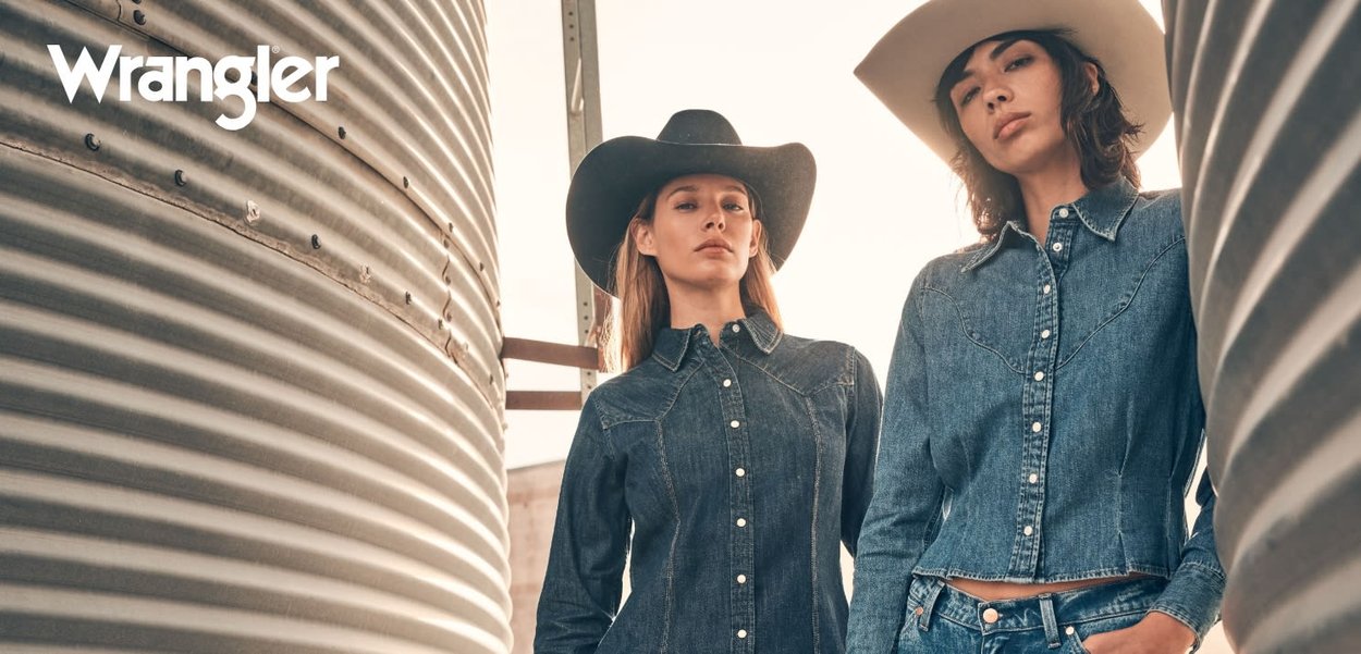 Denimjakker i forskjellige nyanser av blått, med kontraststing og trykknapper, vist mot en rustikk metallbakgrunn.