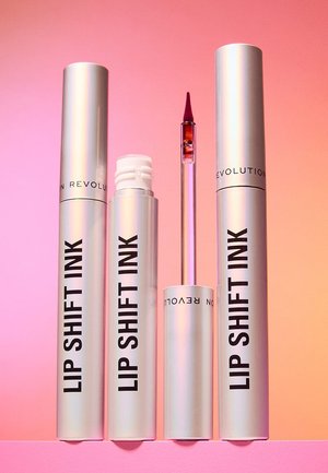 Quattro tubetti metallici color argento di Lip Shift Ink tintura labbra, uno con l'applicatore a bacchetta che mostra una punta rosso scuro, su uno sfondo degradé dal rosa all'arancione.