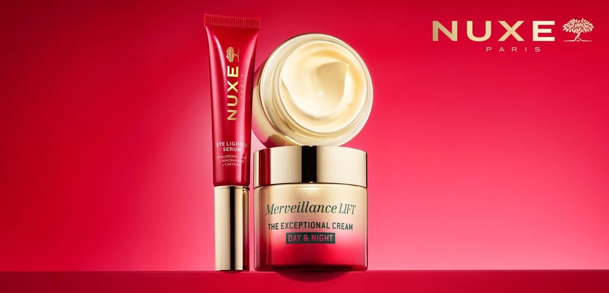 Prodotti per la cura della pelle NUXE: un tubo rosso di siero per gli occhi e un barattolo di crema con coperchio dorato. Texture lisce con finiture opache e lucide in contrasto.