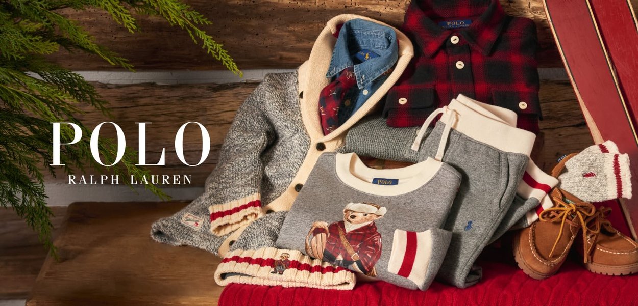 Grå strikkegenser med stripete mansjetter, rød rutete skjorte, blå chambray knapp-opp og brune mokkasiner på teksturert treflate.