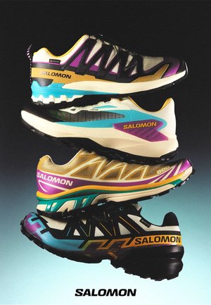 Cuatro zapatillas Salomon coloridas apiladas, con diseños variados, materiales de malla y sintéticos, logotipos de la marca prominentes y suelas contrastantes.