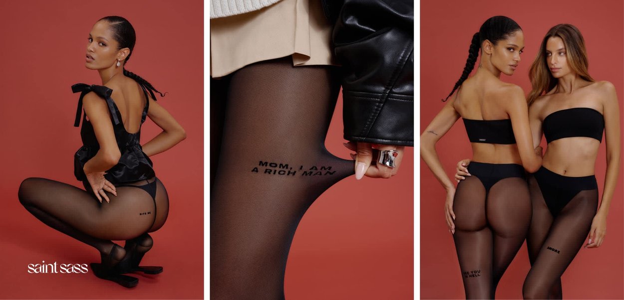 Zwei Frauen in schwarzer Feinstrumpfwaren und minimalistischer schwarzer Kleidung posieren vor einem roten Hintergrund, auf dem Text auf ihren Strumpfhosen zu sehen ist.