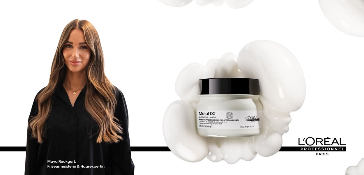 Witte pot met etiket "Metal DX" en een zwarte deksel, romige substantie die eromheen lekt, en een vrouw met lang bruin haar in een zwarte top ernaast.