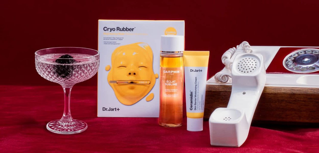 De doos van de Dr.Jart+ Cryo Rubber-masker heeft een geel gezicht ontwerp. Inclusief Darphin essence, Dr.Jart+ crème en een kristallen cocktailglas met bessen.