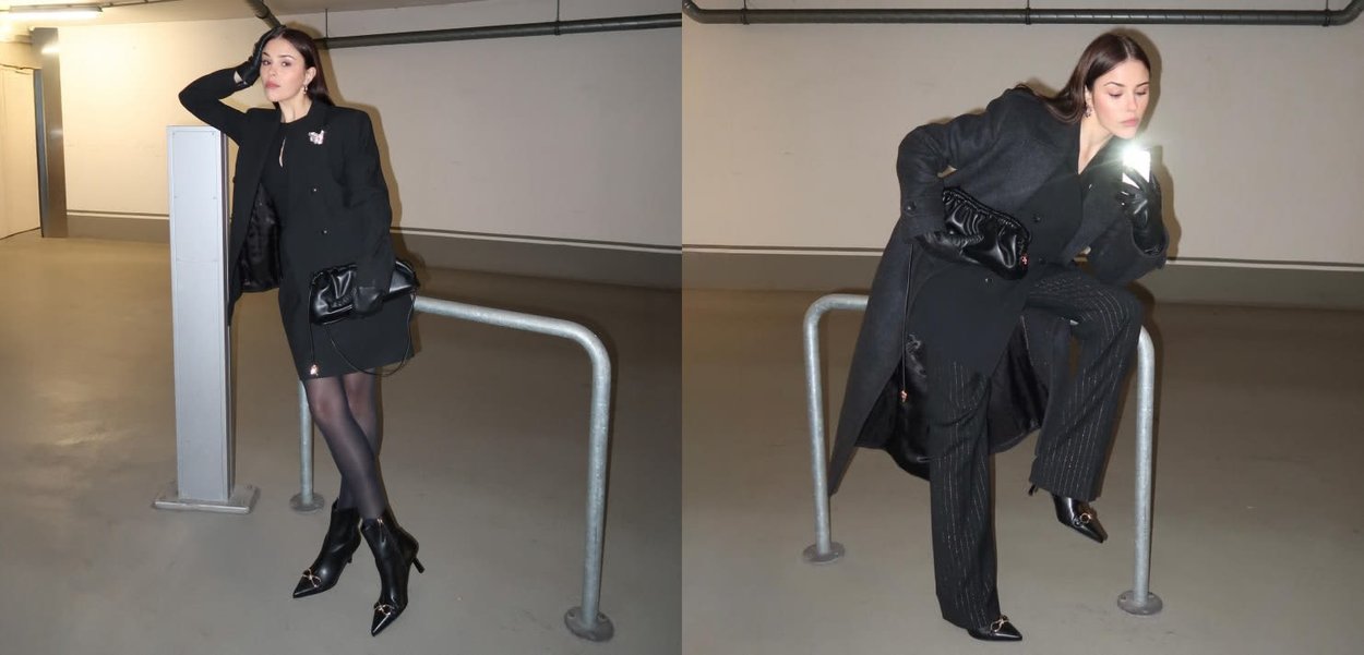 Abrigo negro con un diseño entallado, combinado con pantalones de rayas finas. Medias negras transparentes y botas negras brillantes con tacón. Bolso negro y accesorios de joyería.