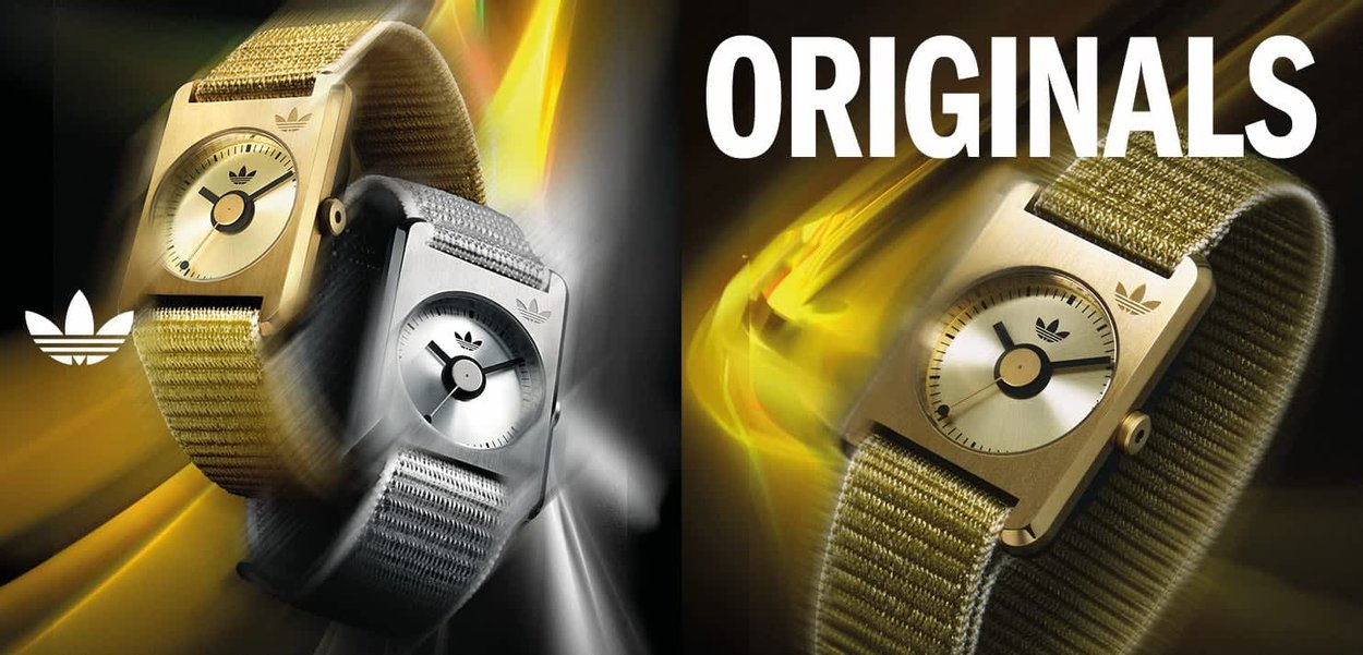 Two square-faced watches with metal cases and textile bands. One features a gold tone with a gold mesh band, the other is silver with a grey band.