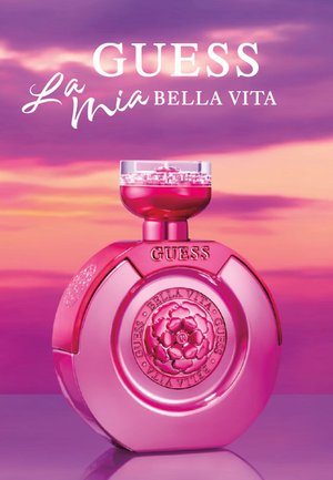 Bottiglia di profumo rotonda rosa con tappo floreale testurizzato, con scritte in rilievo "GUESS" e "BELLA VITA" incise ai lati.