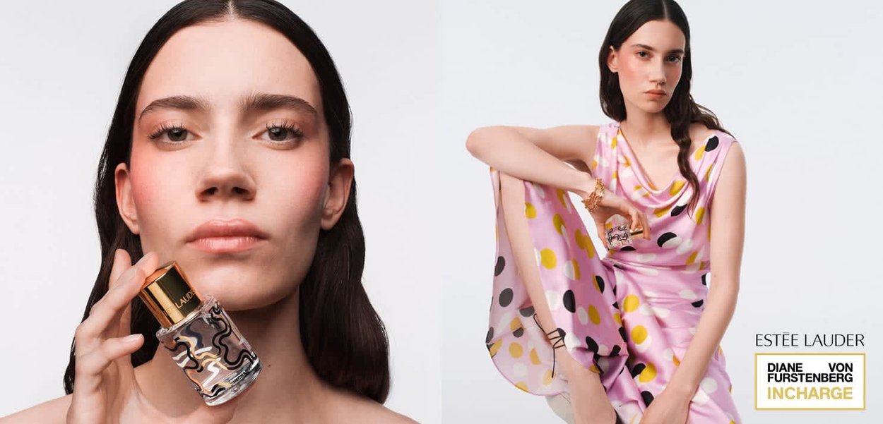 Donna con capelli lunghi e scuri che tiene una bottiglia di profumo Estée Lauder; indossa un vestito rosa con pois gialli e neri, seduta con un braccio appoggiato al ginocchio.