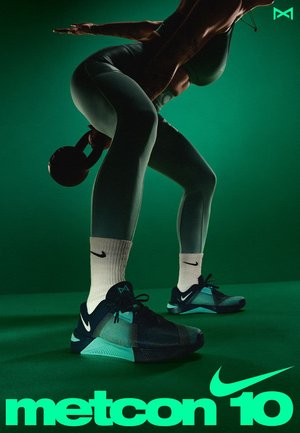 Nike Metcon 10 shoes in dark teal with black accents, featuring a textured upper, cushioned sole, and flat lacing system. Black kettlebell held.