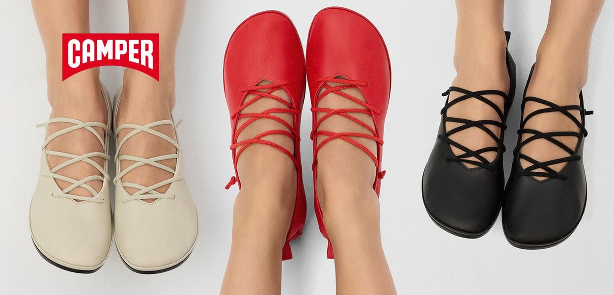 Tre paia di scarpe basse in pelle beige, rosso e nero, con lacci incrociati e punte arrotondate, dalle superfici lisce e con dettagli minimi.
