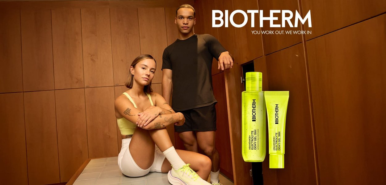 Uomo e donna in abbigliamento sportivo che posano in uno spogliatoio accanto a due prodotti Biotherm Aquasource Electrolyte Dewy Gel di colore giallo neon.
