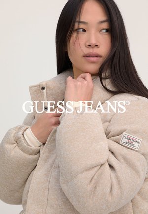 Puffige beigefarbene Jacke mit strukturiertem Finish, hohem Kragen und Frontreißverschluss. Verfügt über ein Markenpatch auf dem linken Ärmel zur Identifikation.