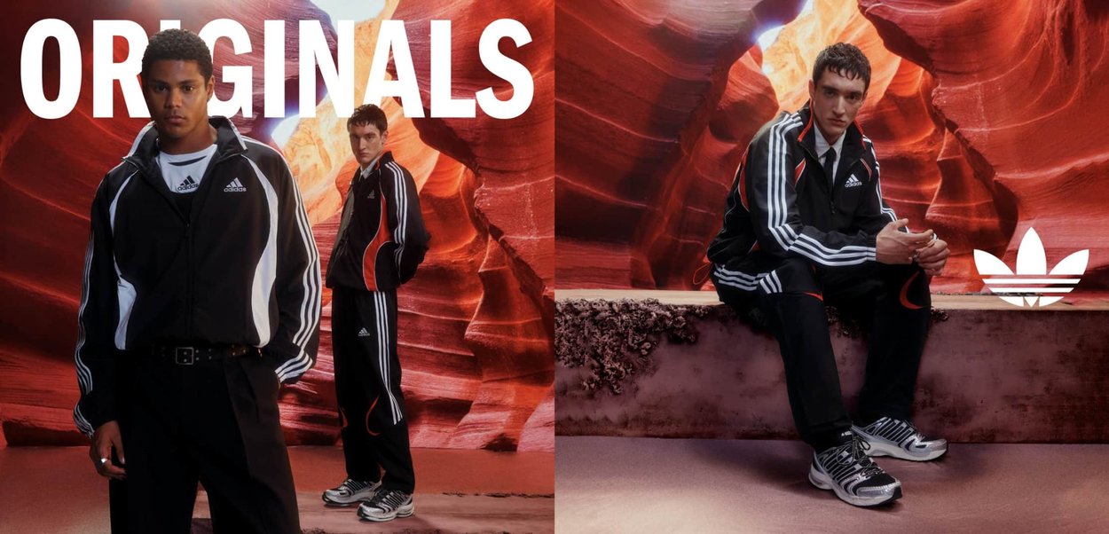 Dos hombres con chándales Adidas Originals negros posando frente a paredes de cañón de roca roja vibrante, uno de pie y otro sentado.