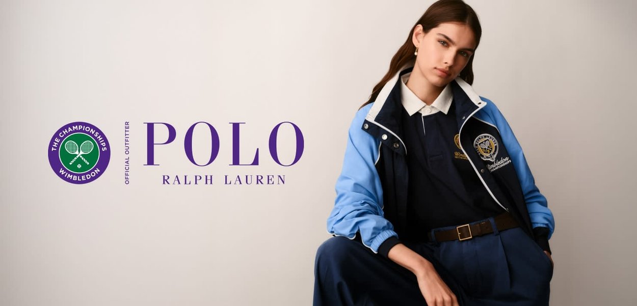 Mujer joven con chaqueta y polo Ralph Lauren Wimbledon en azul marino y azul, sentada frente a un fondo liso con los logotipos de Polo Ralph Lauren y Wimbledon.