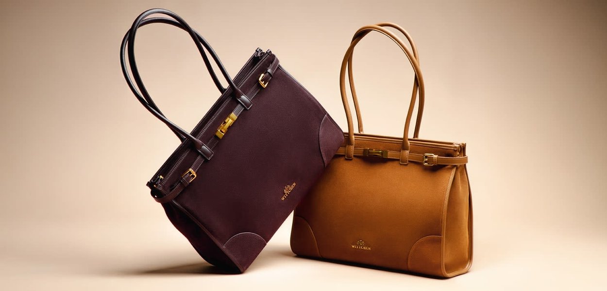 Dwie torebki: jedna ciemnofioletowa z złotymi okuciami i przeszyciami, druga jasnobrązowa o ustrukturyzowanym wzorze i dopasowanymi akcentami.