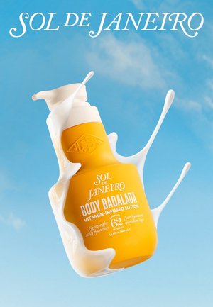 Helle gelbe Sol de Janeiro Body Badalada vitaminreiche Lotion in einer Flasche, umgeben von weißer Flüssigkeit vor einem klaren blauen Himmel.