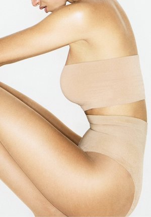 Nacktes nahtloses Bandeau-Top und hochgeschnittene Unterwäsche, glatte Textur, minimalistisches Design, enganliegend, aus weichem, dehnbarem Stoff gefertigt.
