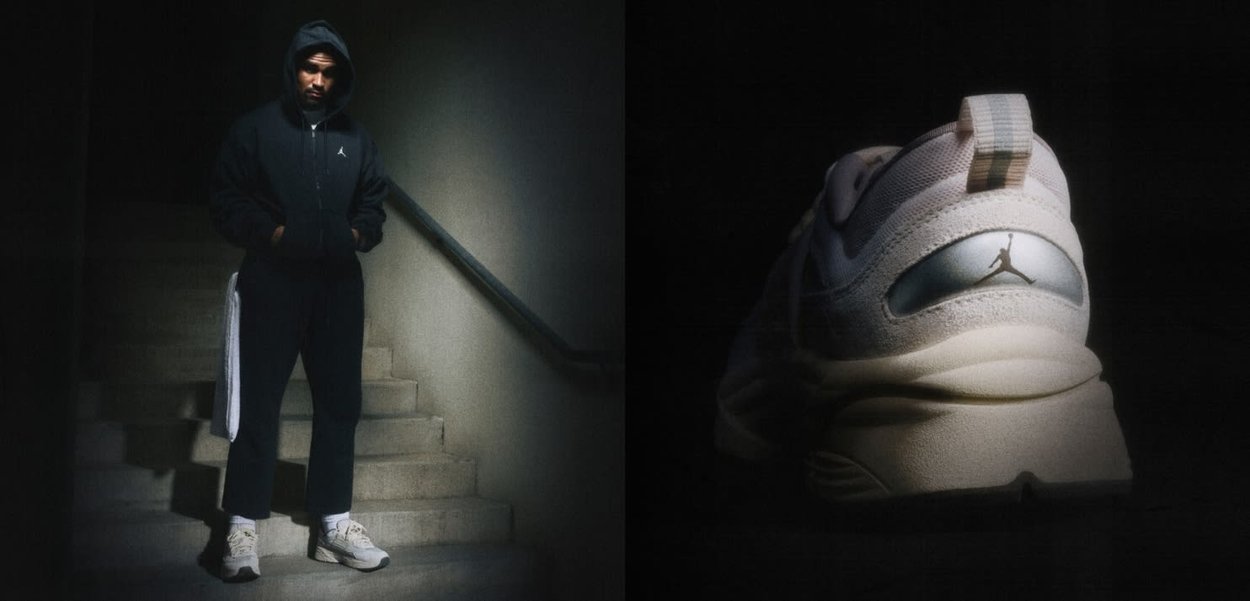 Homme en sweat à capuche et pantalon sombres debout sur des escaliers, portant des baskets de couleur claire ; gros plan sur le talon de la basket avec le logo Jordan à droite.