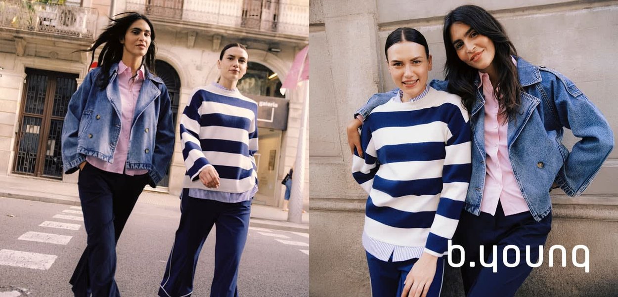 Zwei Frauen gehen und posieren im Freien; eine trägt eine Jeansjacke mit pinkem Hemd, die andere einen blau-weiß gestreiften Pullover mit marineblauen Hosen.