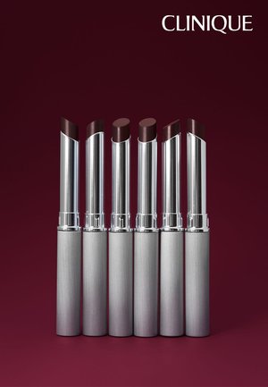 Sei tubi d'argento di rossetto bordeaux scuro in piedi su uno sfondo bordeaux scuro abbinato con il logo Clinique.