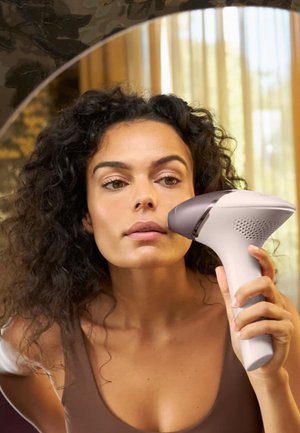 Appareil d'épilation portatif au design blanc et gris, doté d'une surface lisse, d'une forme ergonomique et d'un côté ventilé.