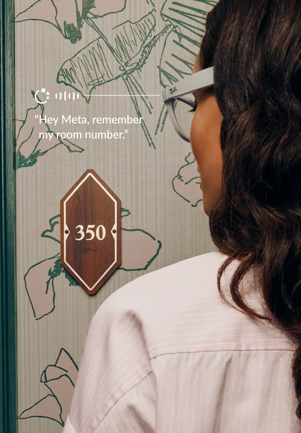 Panneau de numéro de chambre en bois foncé, en forme de diamant avec le numéro blanc "350". L'arrière-plan présente des illustrations florales vertes sur un tissu clair.