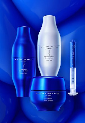 Four Shiseido skincare products: two blue and one white bottle, a blue jar, and a syringe applicator, all with sleek, modern designs.
