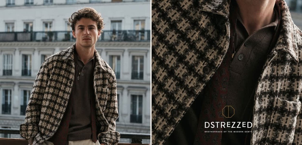 Brown and white houndstooth patterned jacket with a collar, over a dark shirt, featuring a pocket and buttons. Elegant urban backdrop.