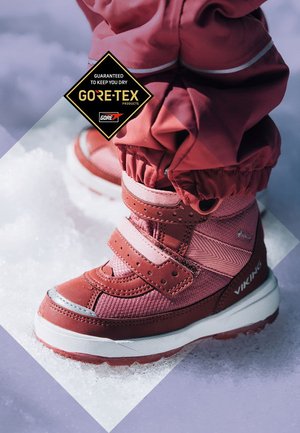 Wodoodporne zimowe buty mid-top w kolorze różowym i bordowym, z rzepami, teksturowanymi panelami z materiału oraz solidną białą podeszwą.