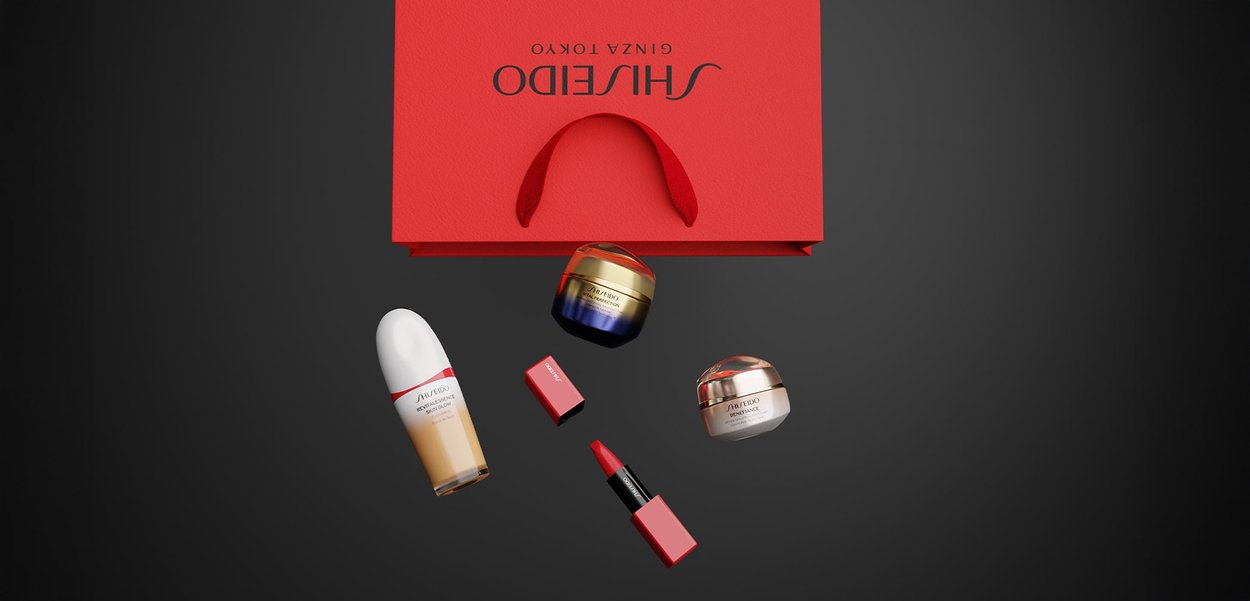 Red Shiseido bag with a handle; contains a white bottle, two jars (gold and cream accents), and two red lipsticks with black detailing.