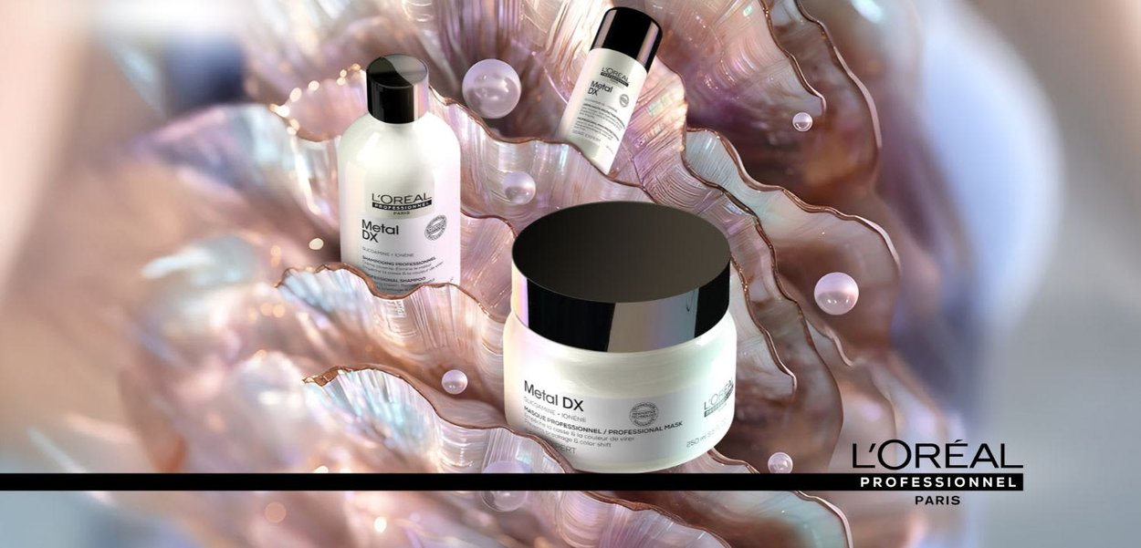 Ligne Metal DX de L'Oréal Professionnel : trois bouteilles avec un design élégant en blanc et noir, des bouchons réfléchissants, sur un fond en coquille irisée.