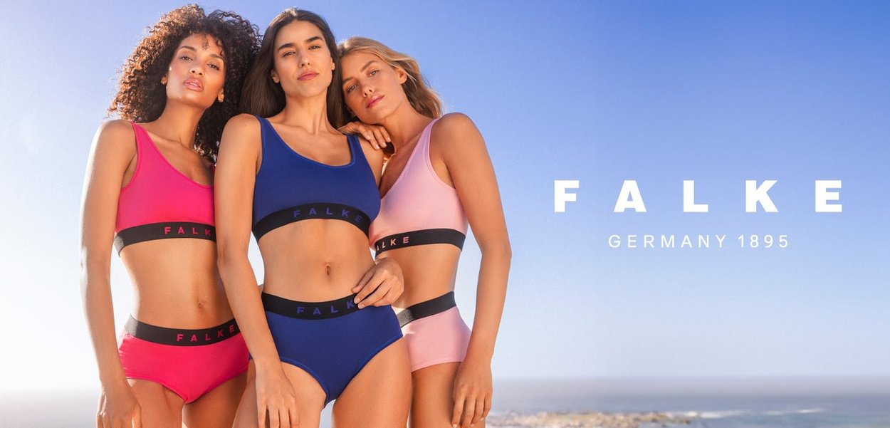 Drei Frauen posieren in passenden Lingerie-Sets: pink, blau und hellpink. Jedes Set hat ein horizontalen schwarzen Streifen mit dem Aufdruck "FALKE" in weiß.