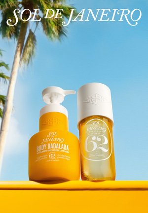 Zwei gelbe Sol de Janeiro Flaschen, Body Badalada Lotion mit Pumpe und Cheirosa 62 Parfümnebel, vor blauem Himmel und Palmenhintergrund.