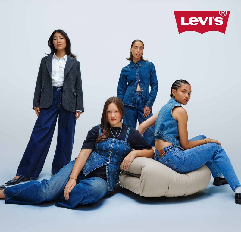 Vier diverse vrouwen in Levi's denim kleding, zelfverzekerd poserend tegen een effen lichte achtergrond met het Levi's-logo erboven.