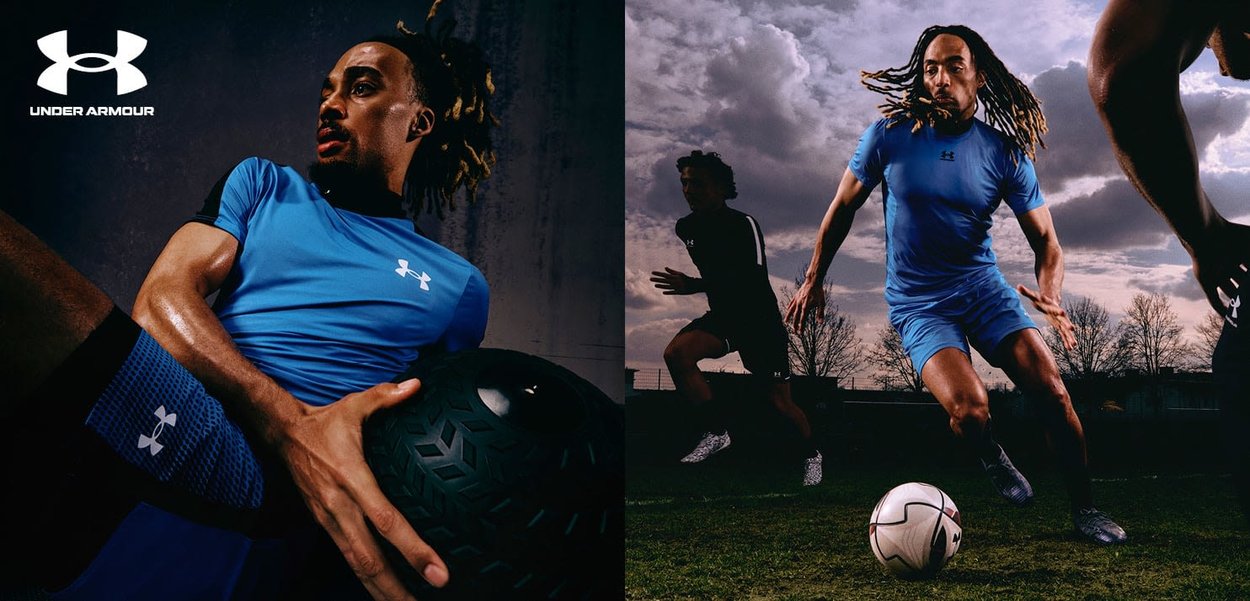 Ropa deportiva de Under Armour en azul, con un diseño ajustado. Incluye una pelota negra texturizada con peso y un balón de fútbol en un campo de hierba.