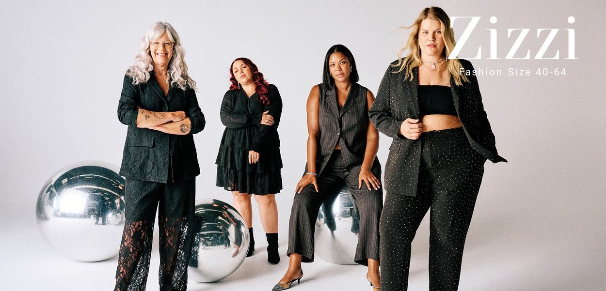 Vier vielfältige Frauen präsentieren stilvolle schwarze Outfits, stehend oder sitzend neben großen reflektierenden silbernen Kugeln vor einem weißen Hintergrund.