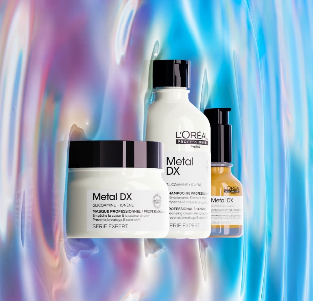 Three L'Oréal Professional Metal DX products: a white jar with a black lid, a white bottle, and a small amber dropper, all featuring clear labels.