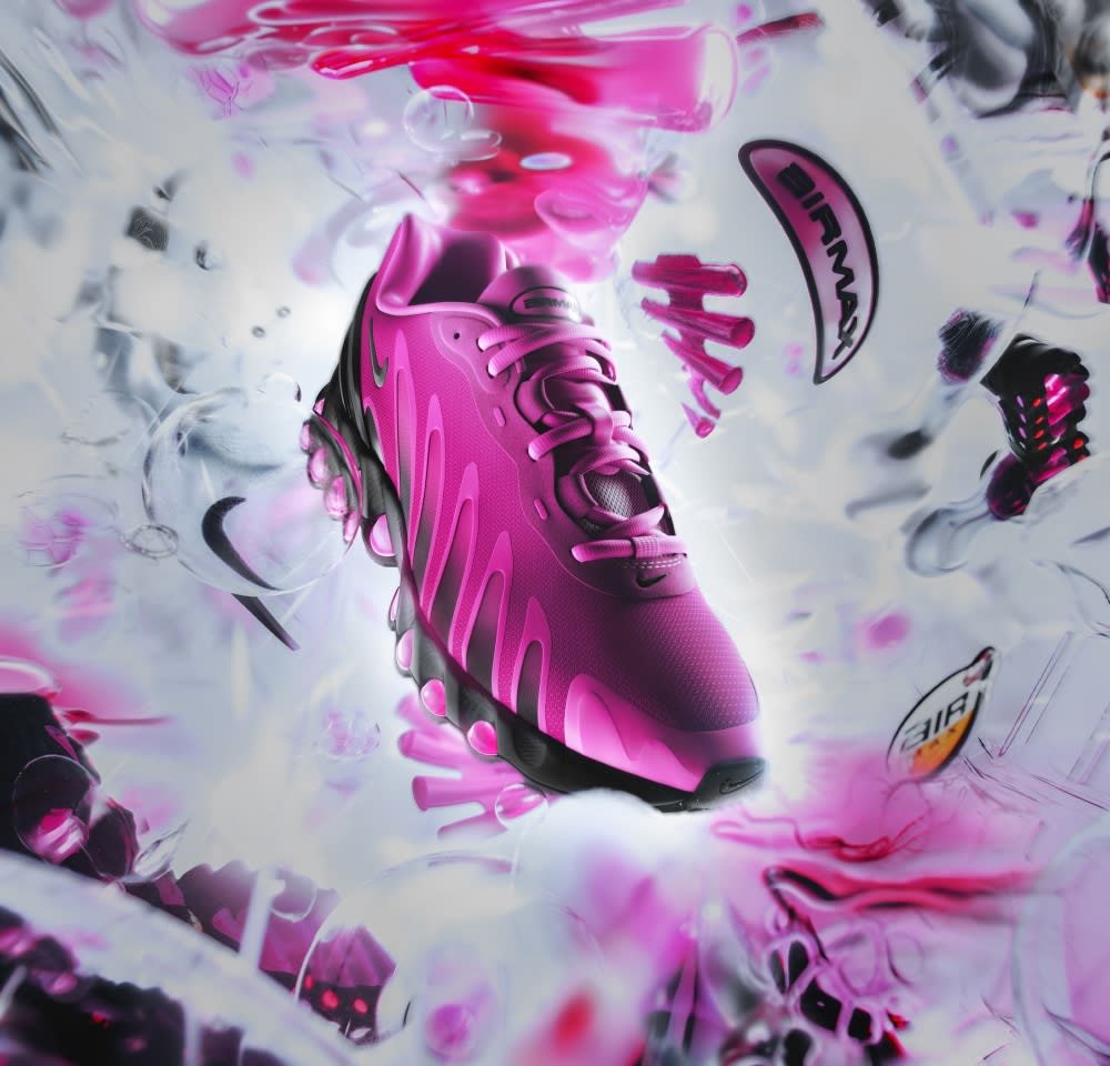 Roze sportief schoen met een gestructureerde bovenkant, heldere veters en zichtbare Air-demping in de zool. Beschikt over een golvend design en merkaanduidingen.