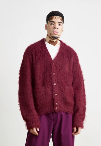 Bordeaux fuzzy cardigan met een diepe V-hals, knoopsluiting en twee voorzakken. Gemaakt van een zachte, gestructureerde stof met lange mouwen.