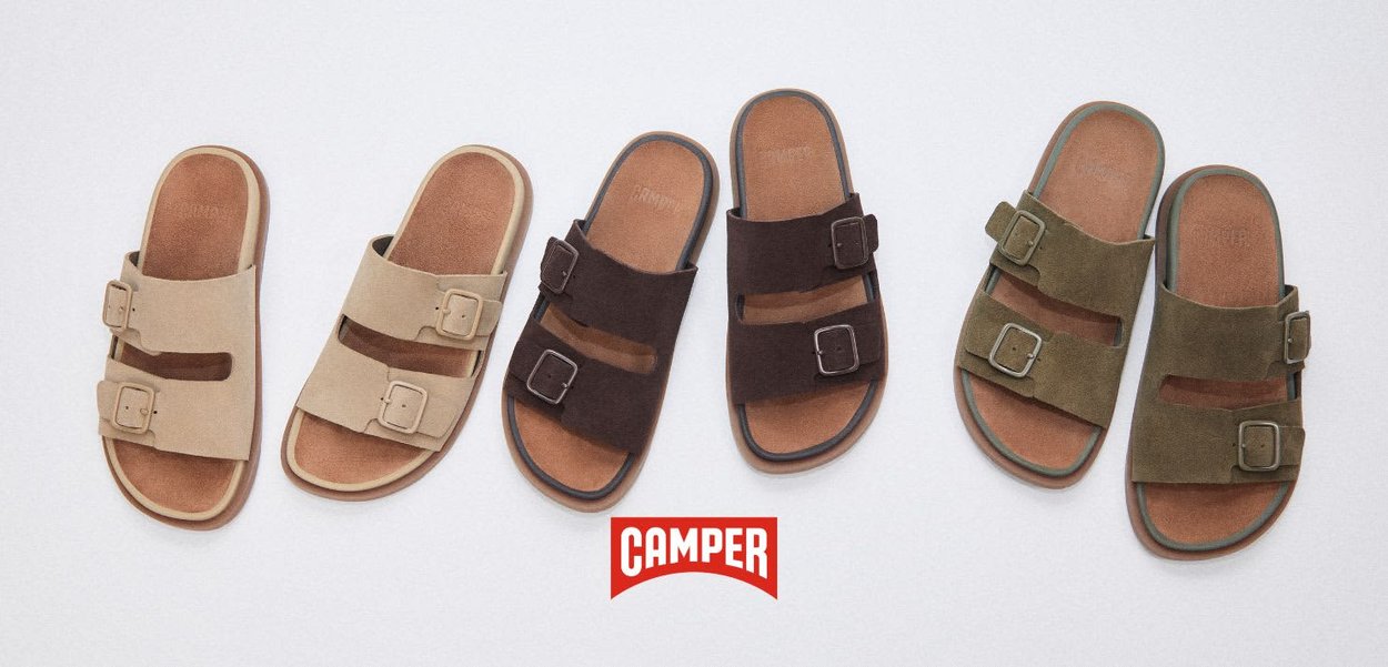 Tres pares de sandalias con hebillas en beige, marrón oscuro y verde oliva, colocadas una al lado de la otra sobre el logotipo de Camper.