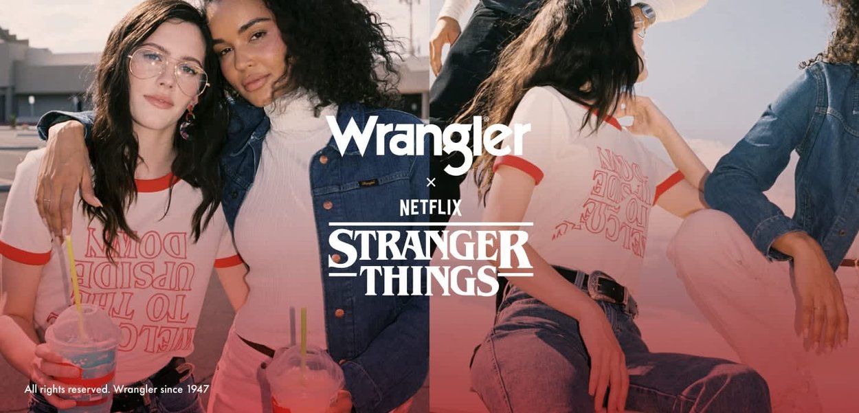 Les chemises Wrangler x Stranger Things présentent des accents rouges sur un tissu blanc, une veste en denim, et deux personnes tenant des boissons dans des poses décontractées.