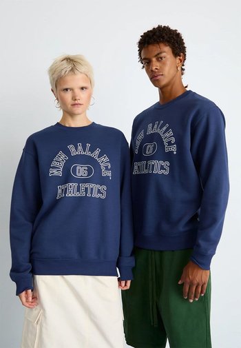 Marineblauwe sweatshirts met de tekst "New Balance Athletics", met een klassieke ronde hals en ribgebreide mouwen. Het materiaal lijkt zacht en dik.