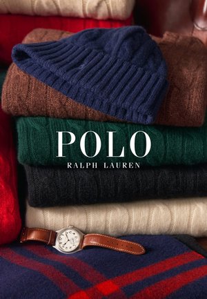 Collection de tricots dans diverses couleurs (marine, marron, vert, rouge, noir, écru), empilés avec une montre en argent dotée d'un bracelet en cuir marron.