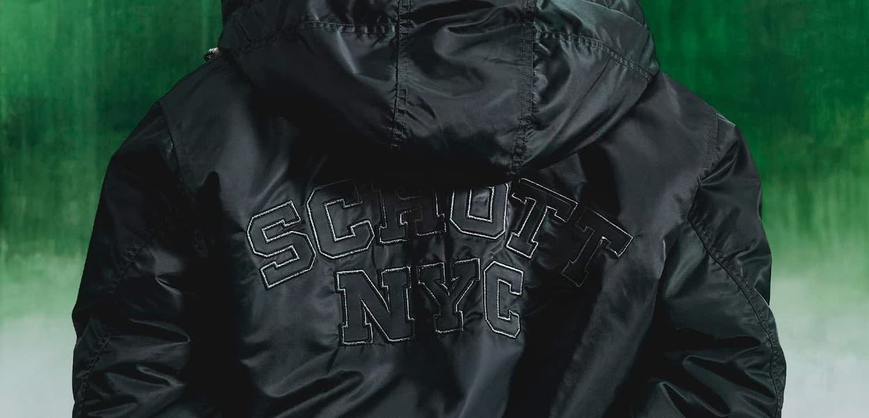 Schwarze Nylonjacke mit verstellbarem Kapuze, gesticktem "SCHOTT NYC" Logo in fetter Schrift über dem Rücken und einer glatten, glänzenden Textur.